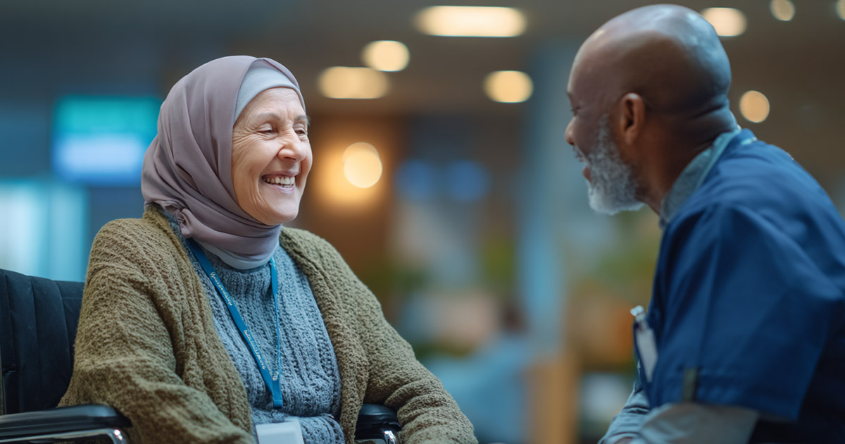 Inclusive healthcare: elderly woman in wheelchair smiling with nurse in clinic lobby
