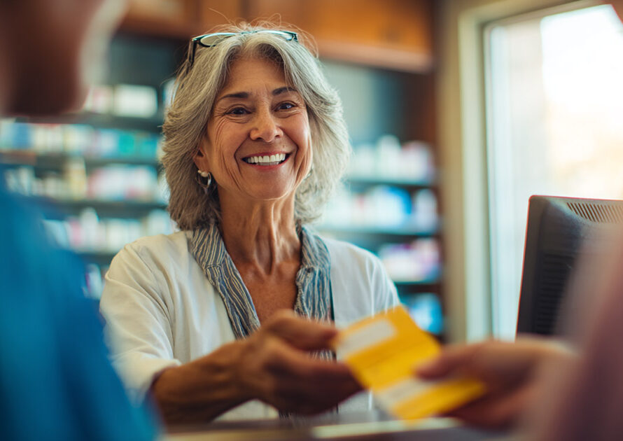 Senior patient getting prescription bottle from pharmacist at drugstore