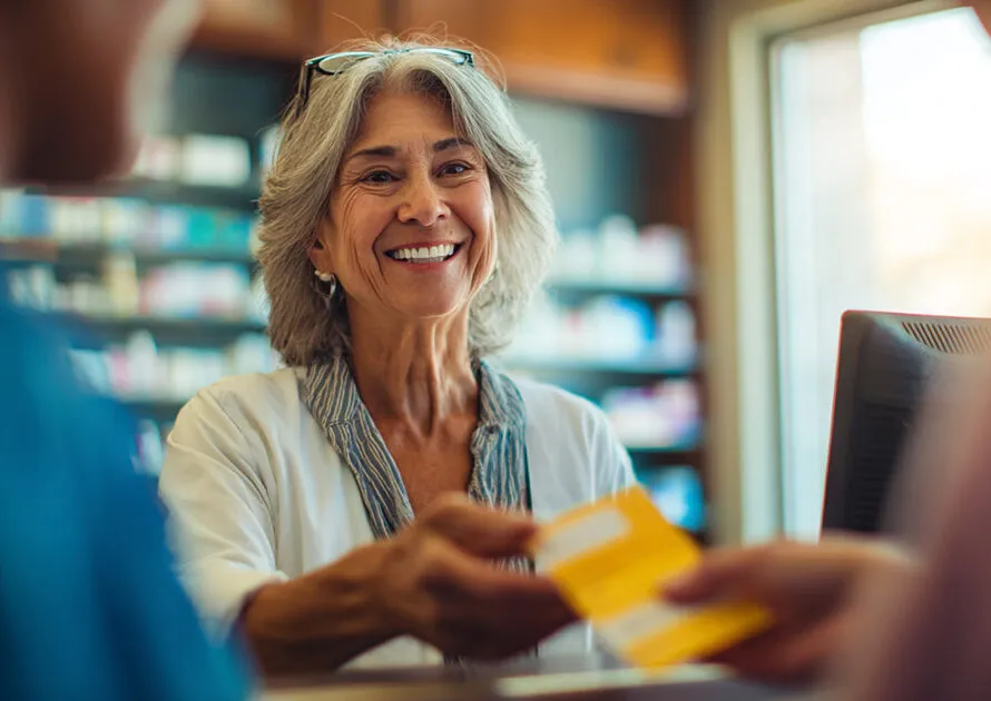 Senior patient getting prescription bottle from pharmacist at drugstore