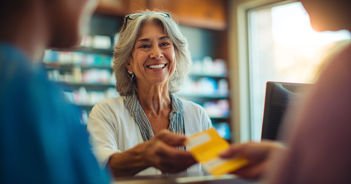 Senior patient getting prescription bottle from pharmacist at drugstore