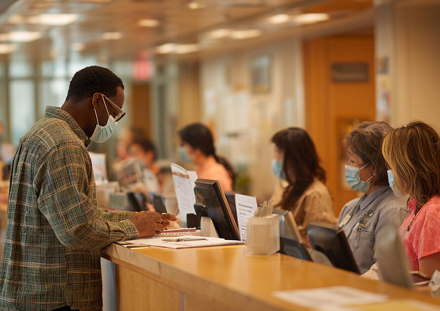 Patient at hospital registration desk affected by medicaid funding cut policies