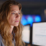 Hospital administrator analyzing healthcare revenue cycle analytics on multiple monitors