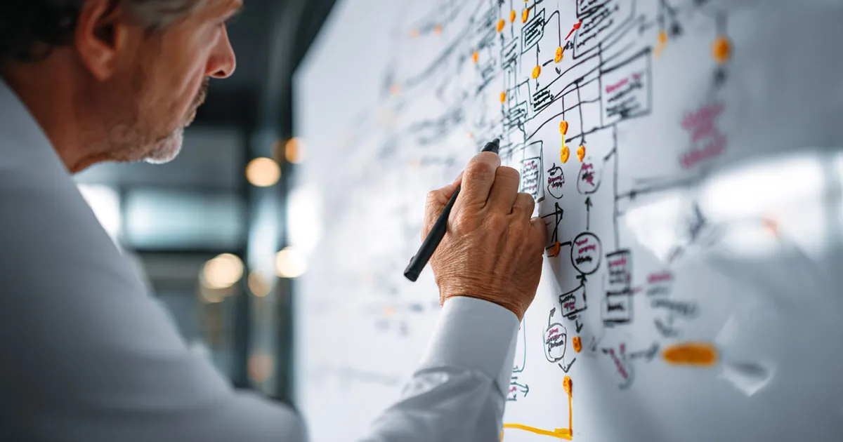 Hospital CFO creating a healthcare revenue cycle flowchart on whiteboard