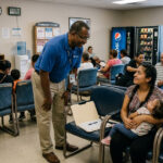 Community hospital worker assisting a young family with paperwork