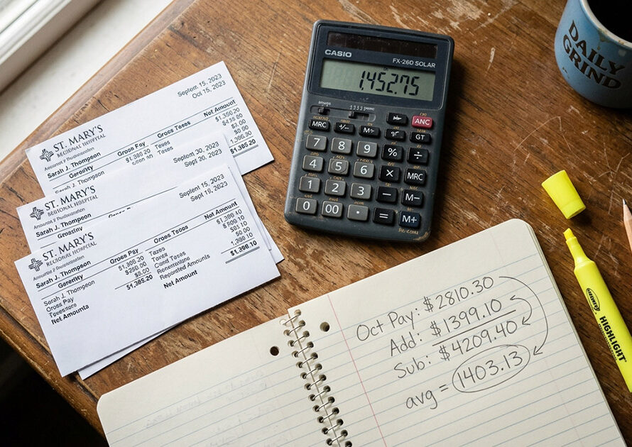 Calculator and pay stubs on a desk for ACA affordability calculations