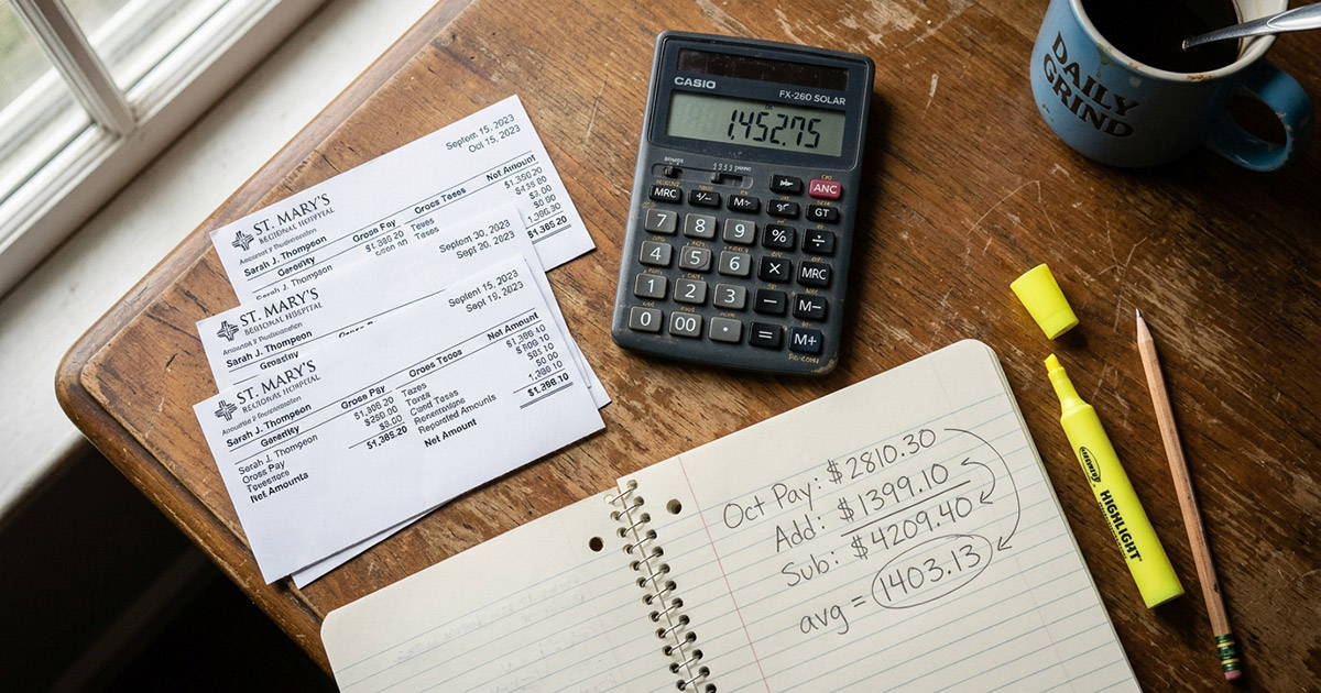 Calculator and pay stubs on a desk for ACA affordability calculations